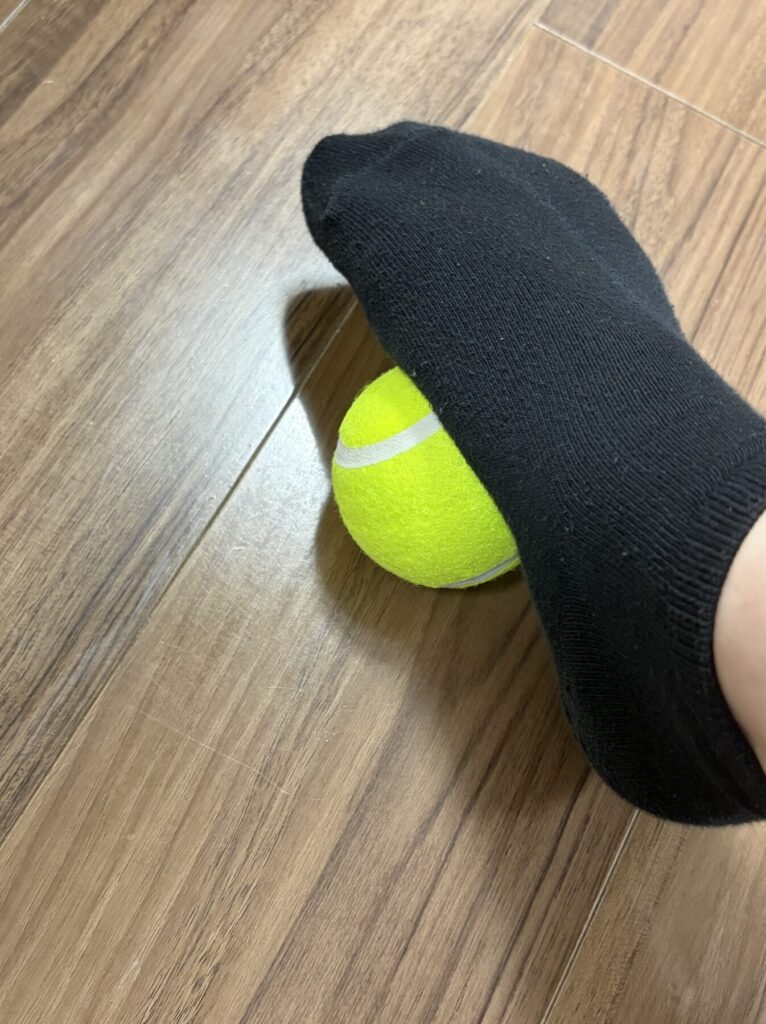 土踏まずにテニスボールを当てている様子